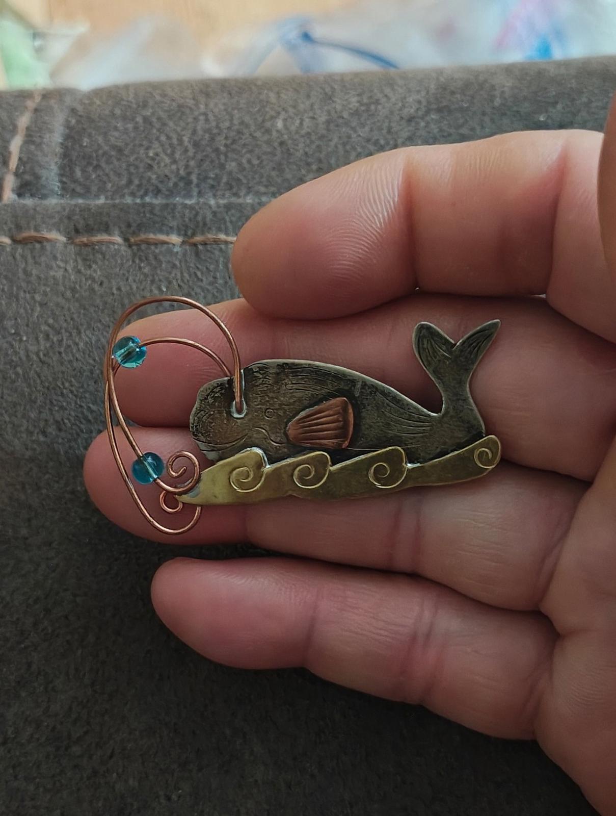 Gold-tone whale brooch pin with full front view, blue stones, copper wire loop, dark green whale