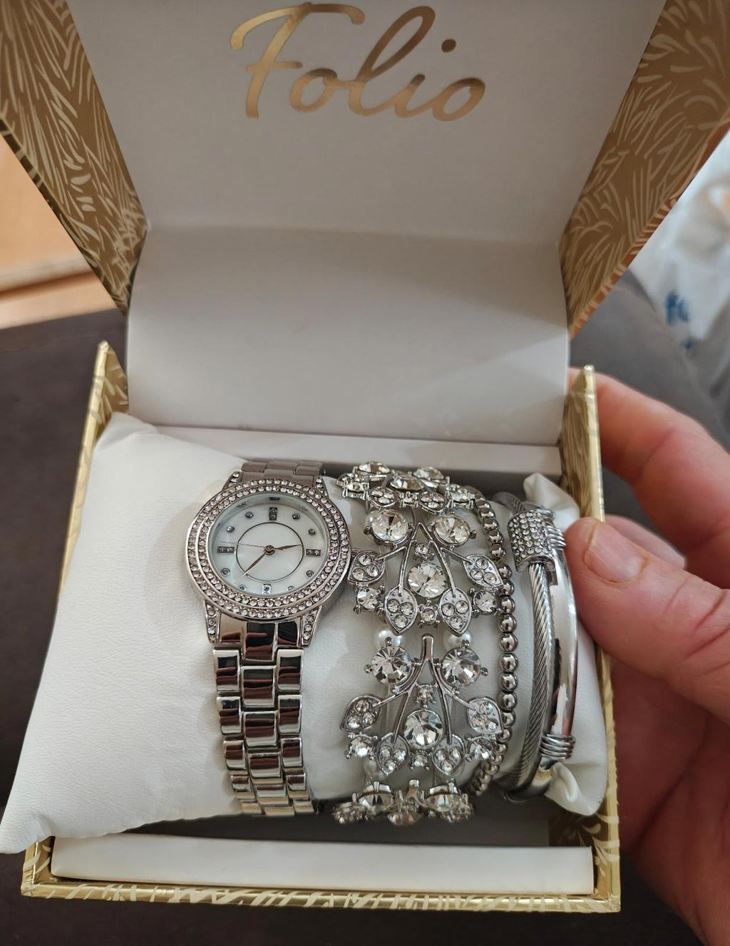 Silver-tone women’s watch set in open Folio box with round dial and jeweled cuffs