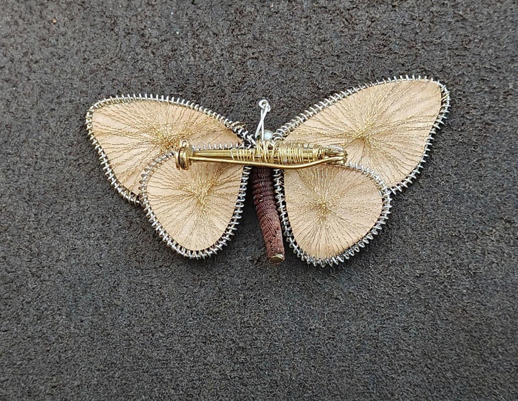 Butterfly brooch pin with gold-tone pin clasp; wire wings and pearl center bead