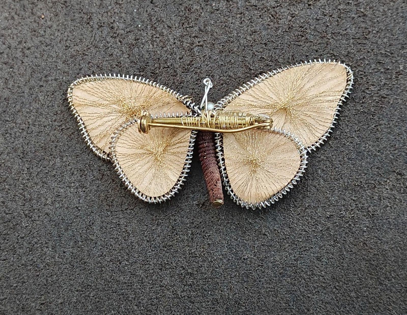 Butterfly brooch pin with gold-tone pin clasp; wire wings and pearl center bead