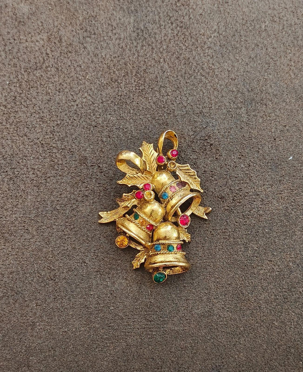 Gold tone Christmas bell brooch with rhinestone bow and clustered colored gems on bell