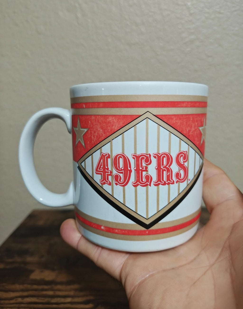San Francisco 49ers diamond logo mug with red star accents and striped pattern.