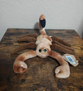 Brown plush scorpion with curled tail, floppy legs, and light tan face with blue eyes