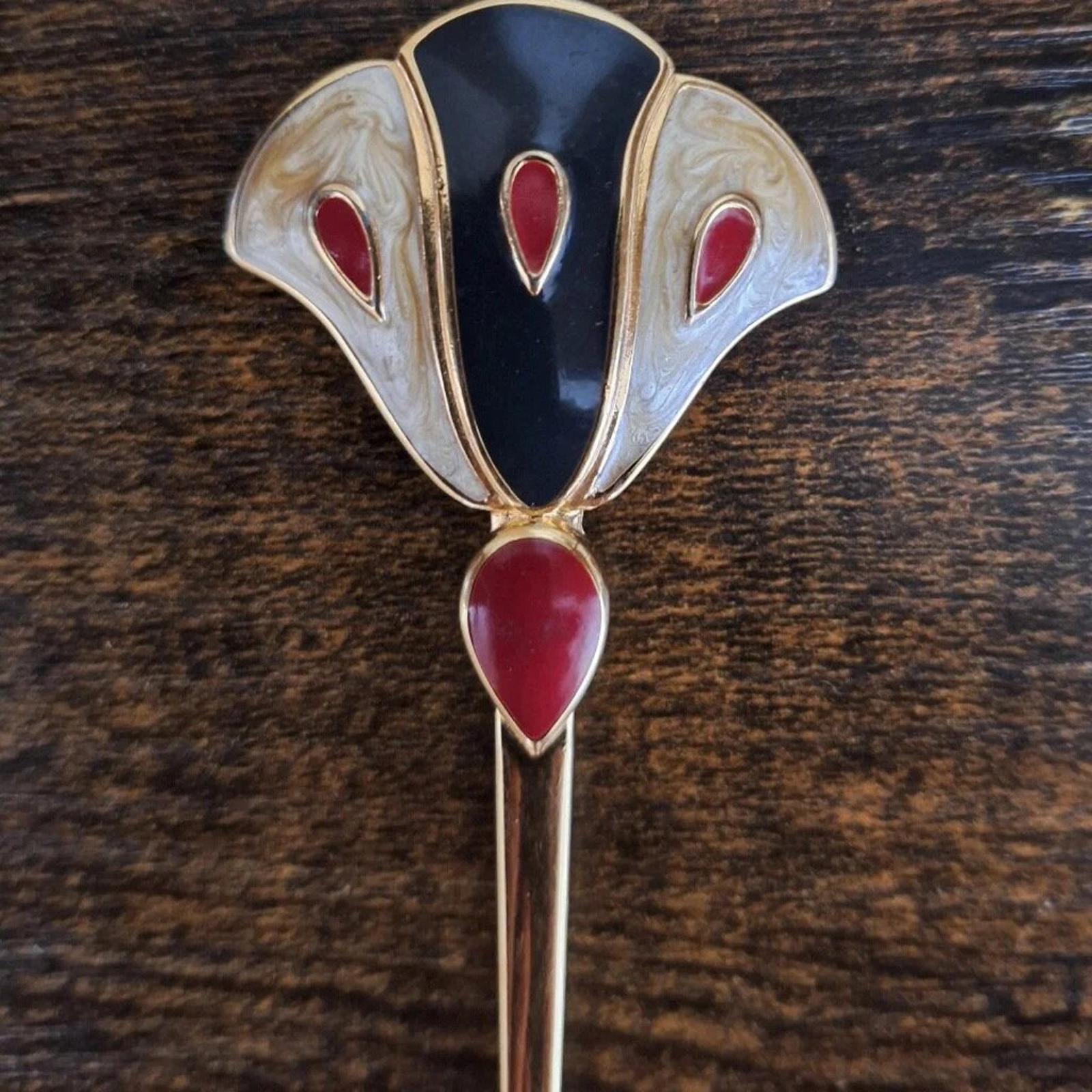 Gold enamel flower pin brooch with dark blue teardrop center and red drop-shaped petals