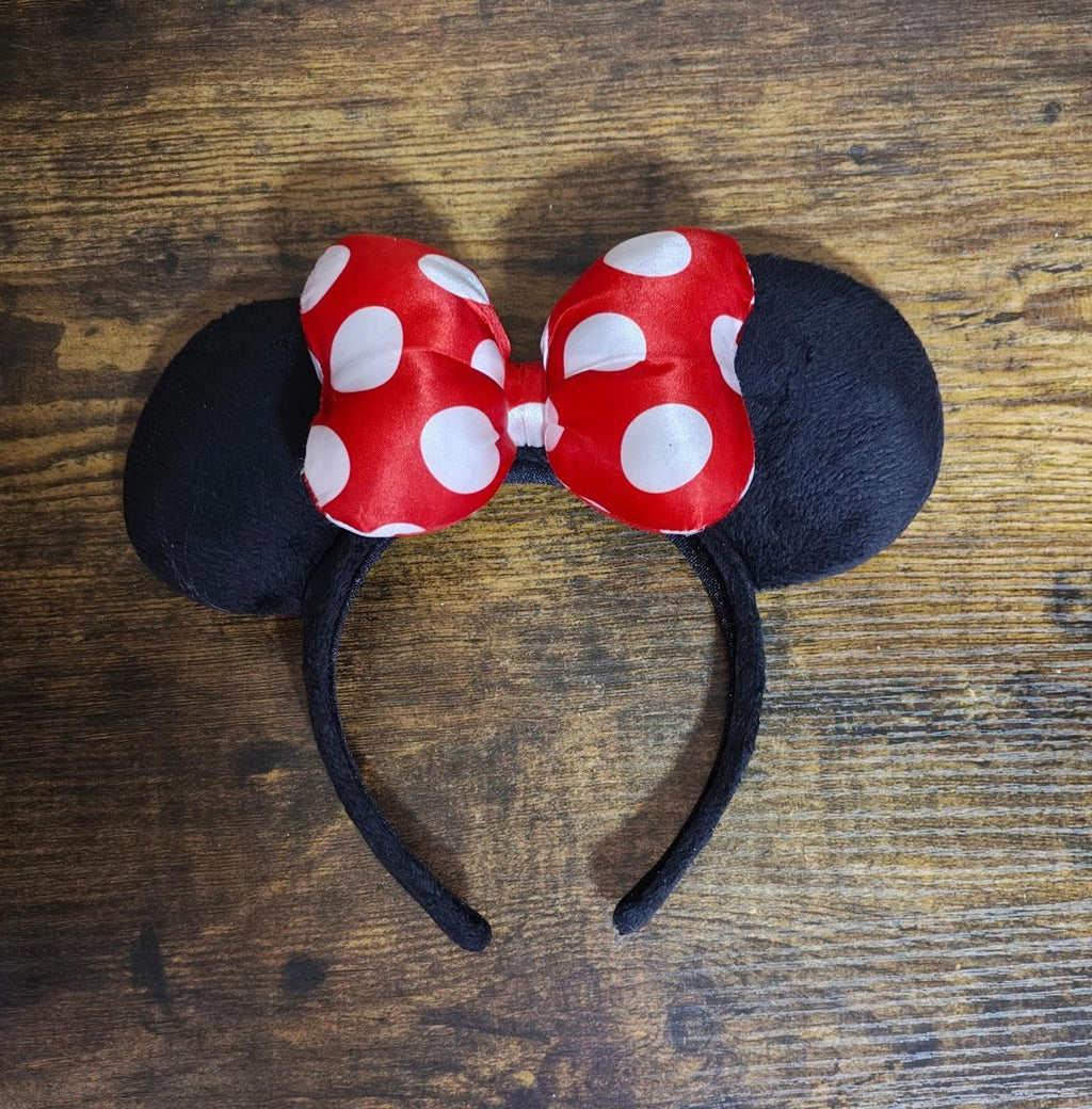 Overhead view of red and white polka-dot bow ear headband with black fabric ears