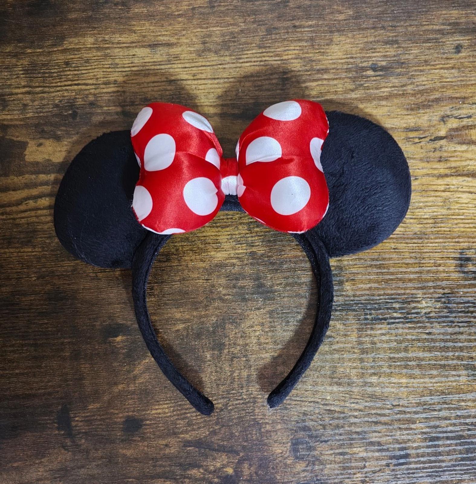 Overhead view of red and white polka-dot bow ear headband with black fabric ears
