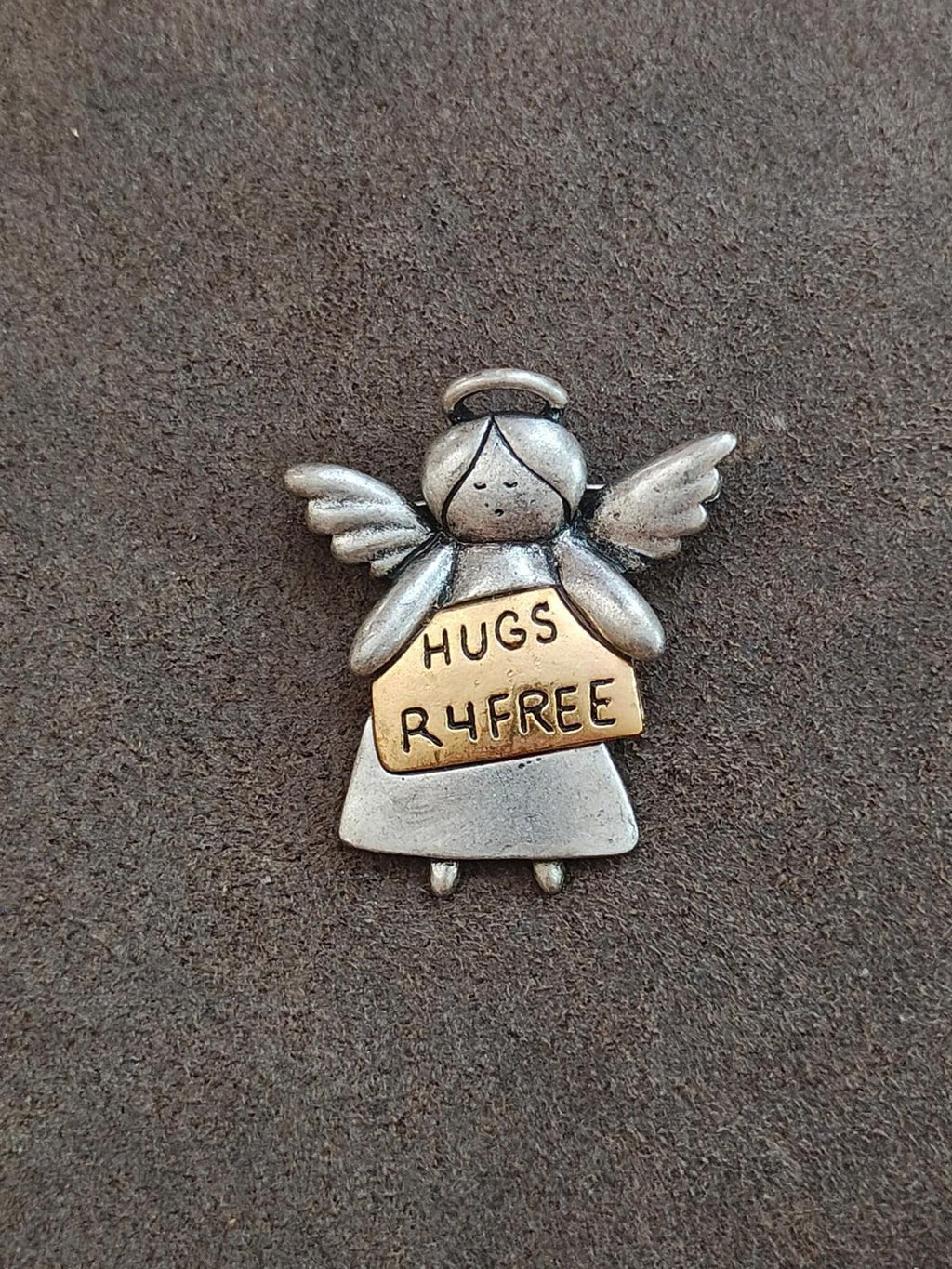 Silver winged angel charm brooch with tan sign reading HUGS R4FREE