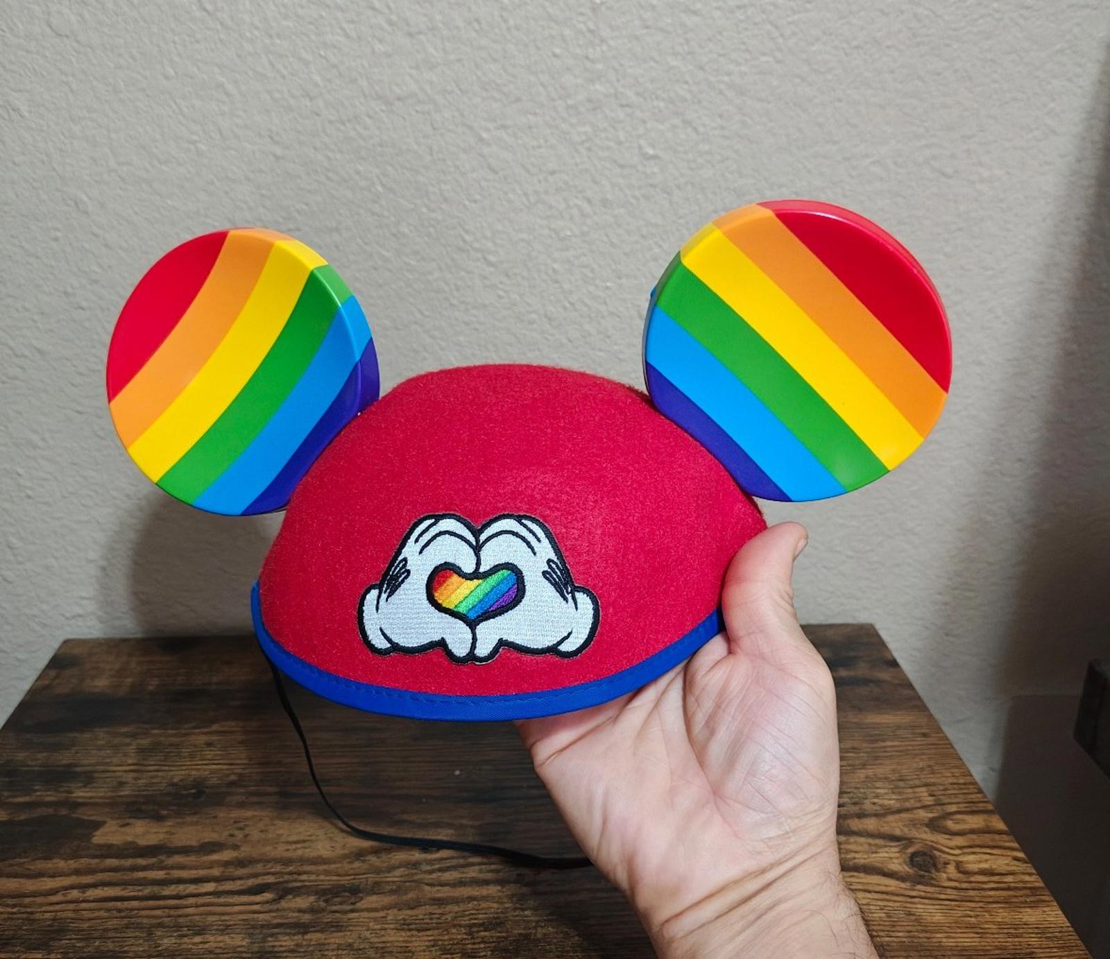 Red felt Mickey Mouse ear hat with rainbow-striped ears and heart-love graphic
