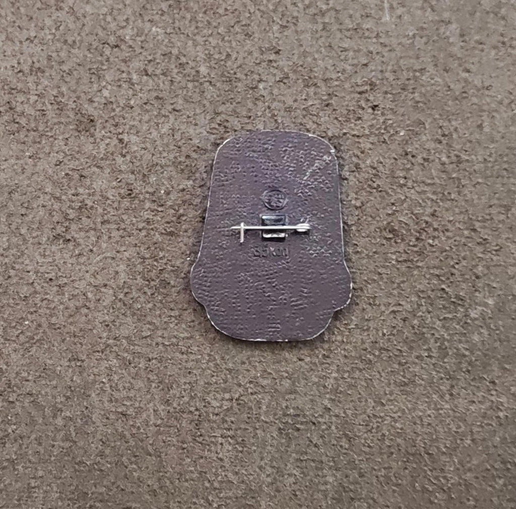 Silver back of a children's enamel pin with pin clasp and safety bar