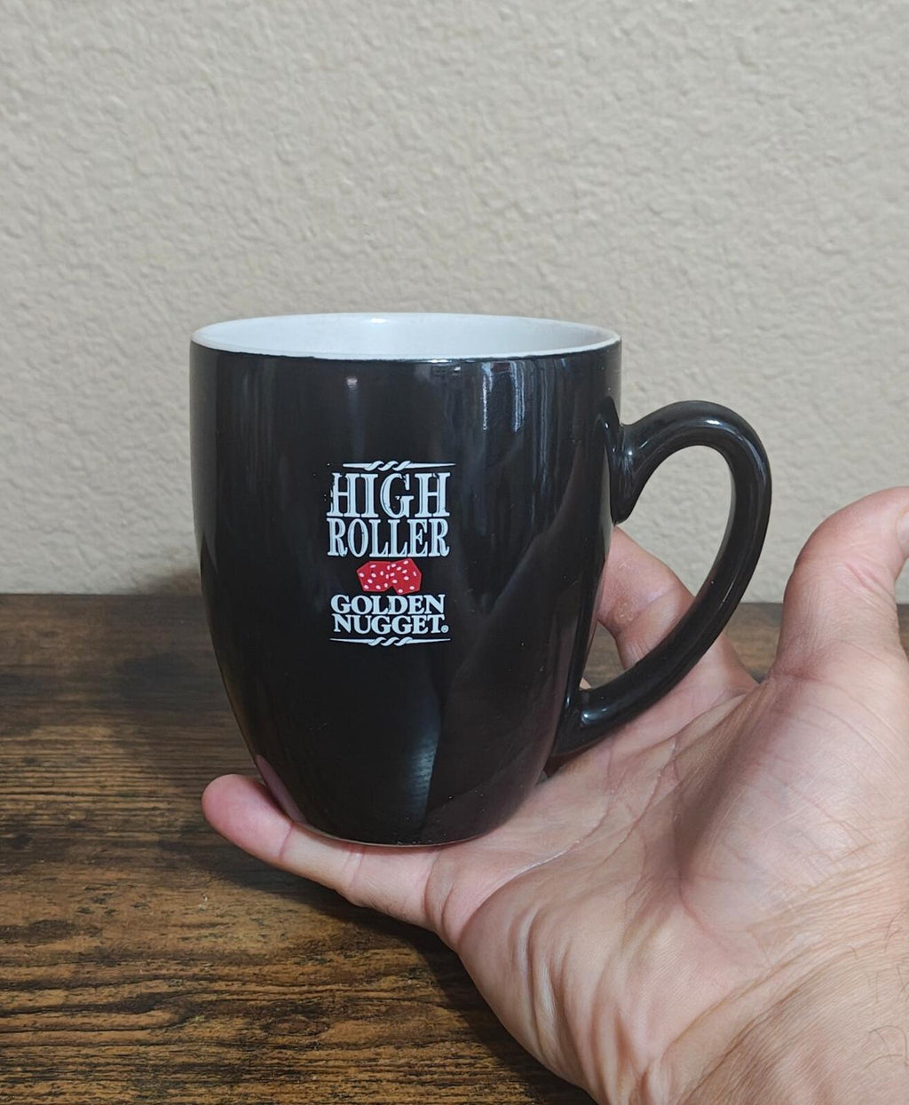 Black mug with High Roller and Golden Nugget logo on front, C-handle