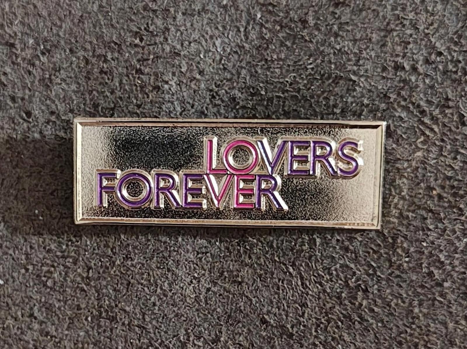 Gold-tone “Lovers Forever” enamel pin, centered front view with purple and pink text.