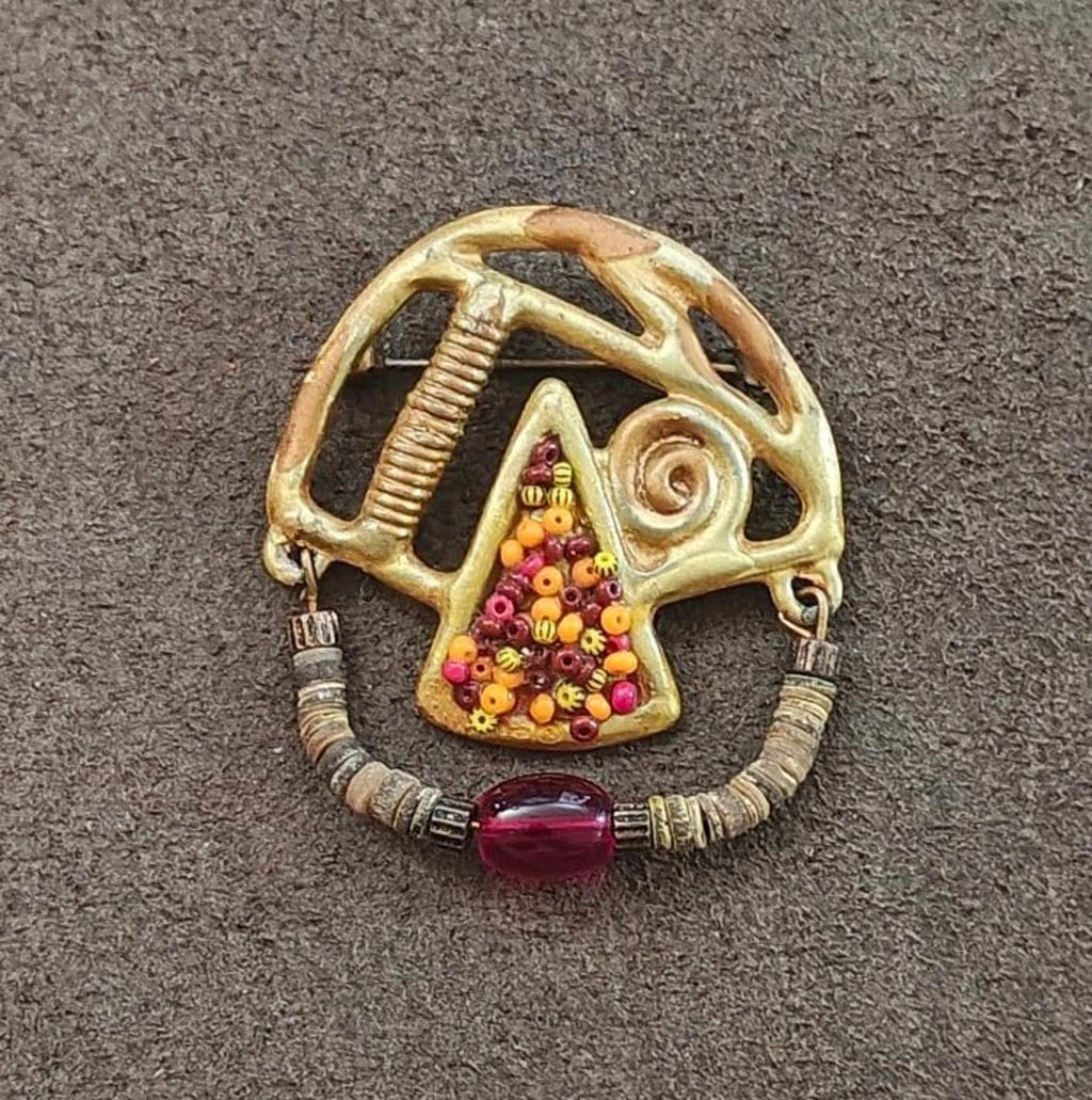 Gold-tone abstract pin with multicolor bead cluster triangle, spiral detail, red stone
