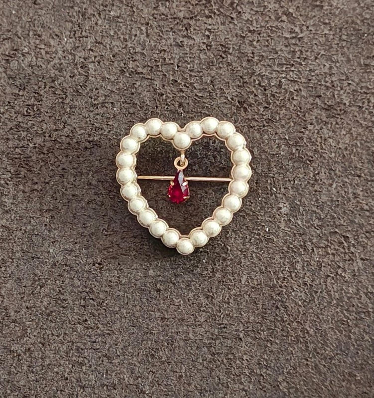 Heart brooch with white faux pearls and a red teardrop rhinestone center on gold backing