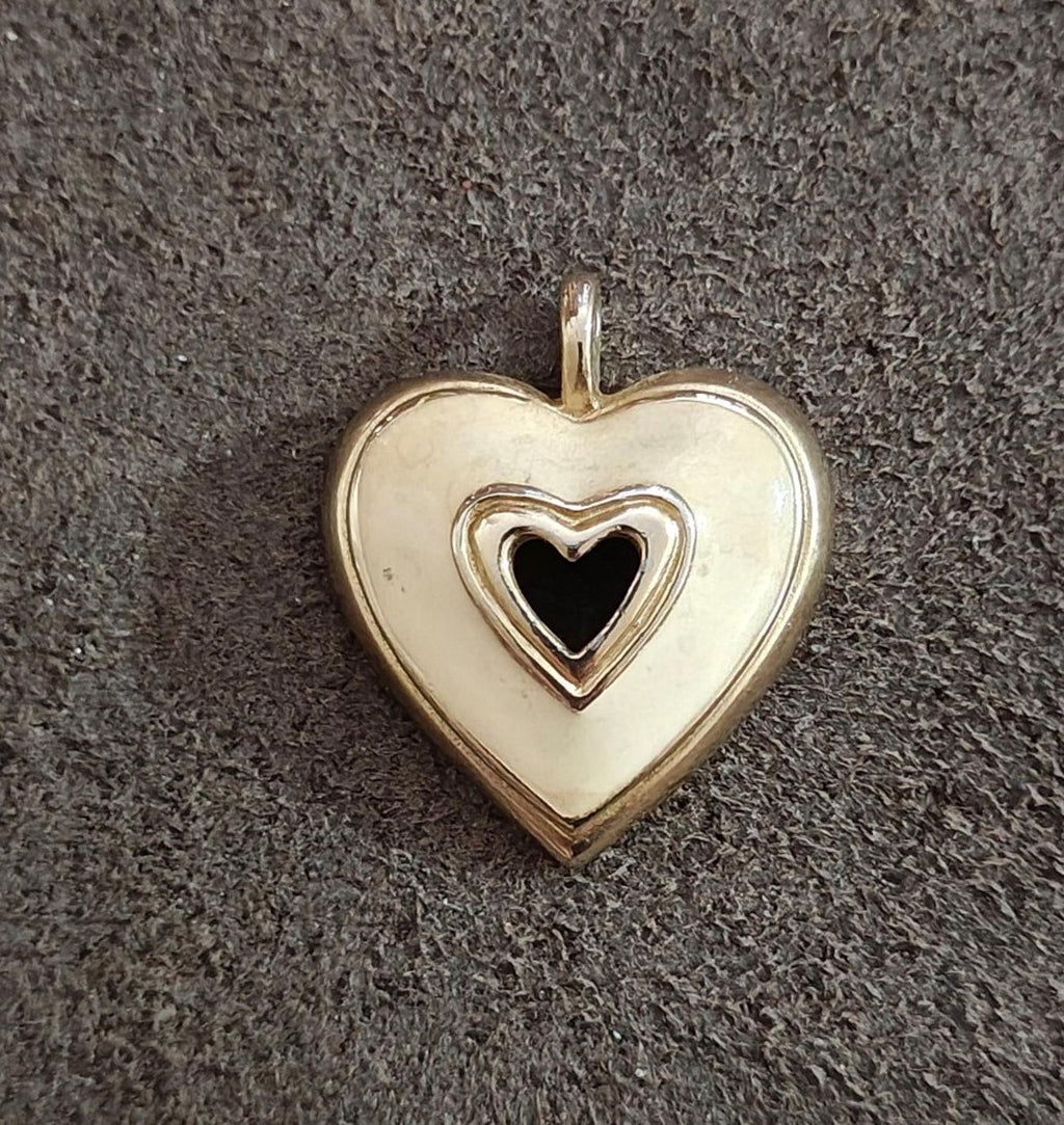 Gold tone heart pendant with white enamel and black heart inset, hanging loop