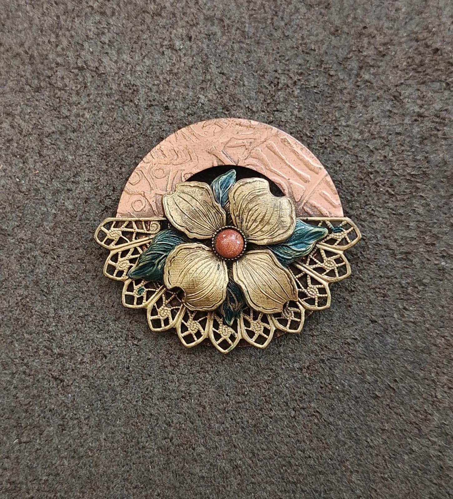 Gold-tone floral enamel brooch with red center bead, blue-green petals, round textured backing