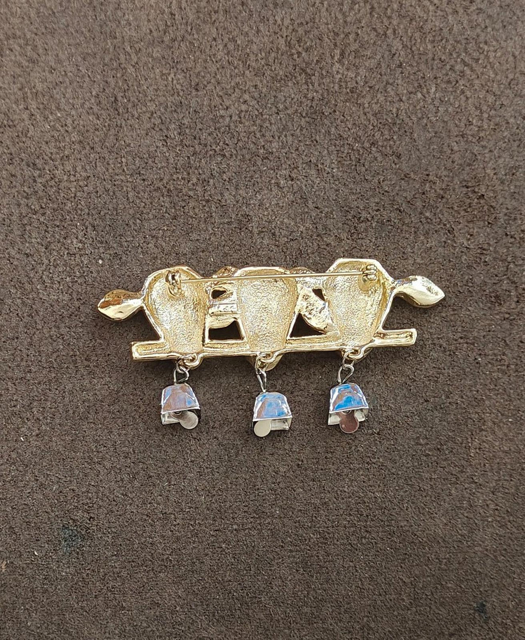 Gold-tone cow head bar brooch with three dangling silver bells and blue enamel tops
