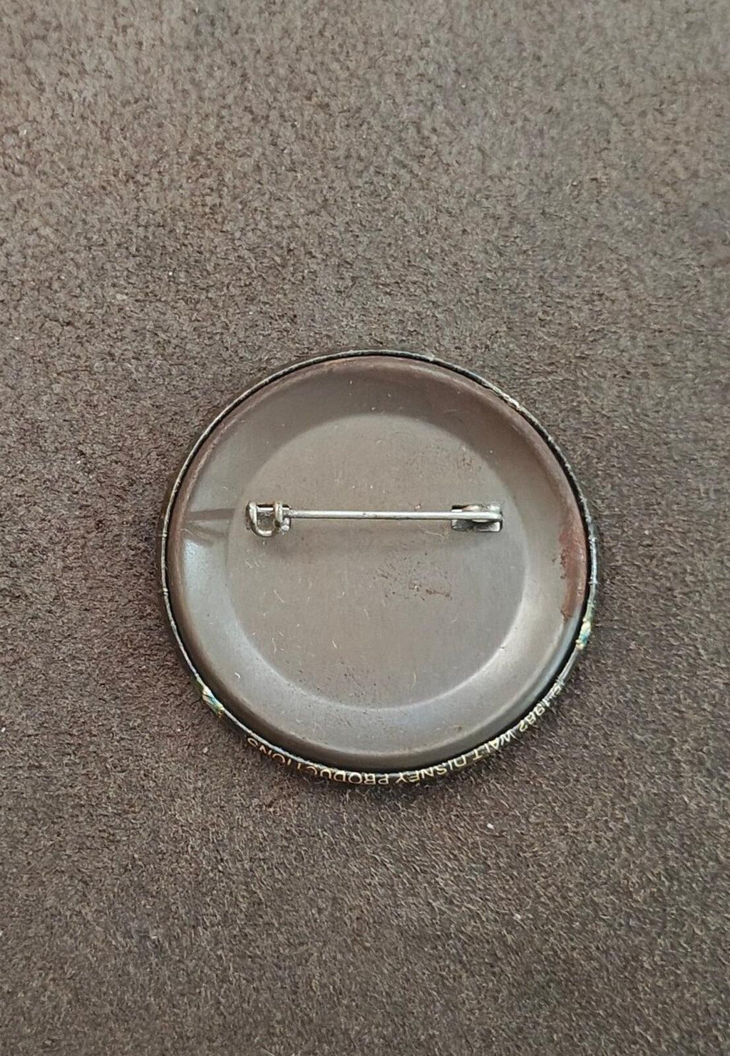 Round pinback with silver-tone backing, safety pin stem and clasp