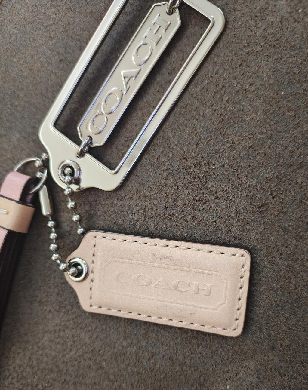 Coach logo metal frame charm with pink strap and beige leather hang tag