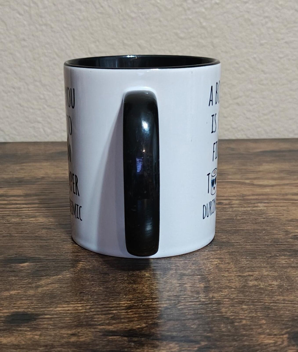 White mug side view with black inner rim, glossy black vertical handle.