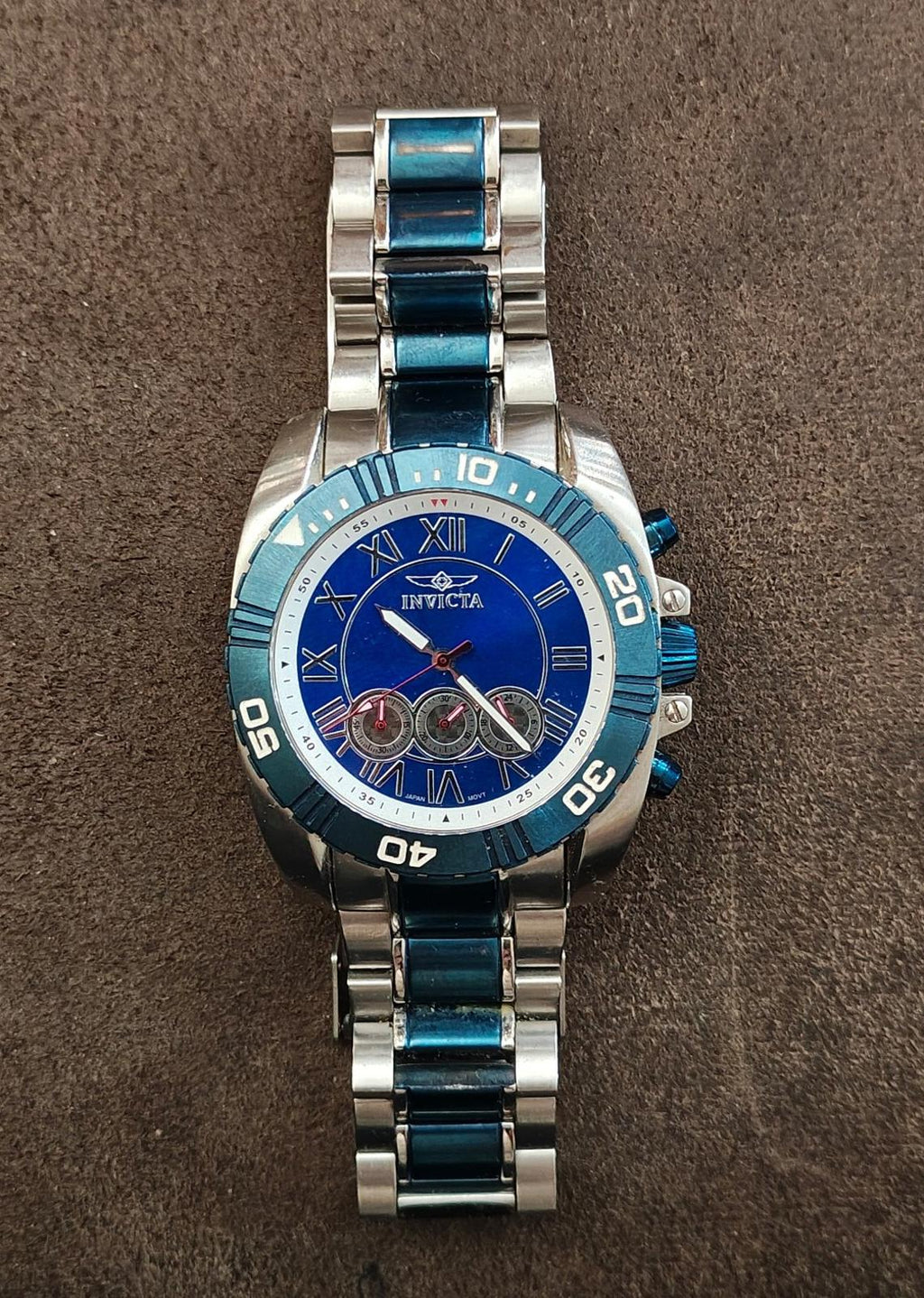 Men's blue chronograph wristwatch with blue bezel, silver case, and three subdials