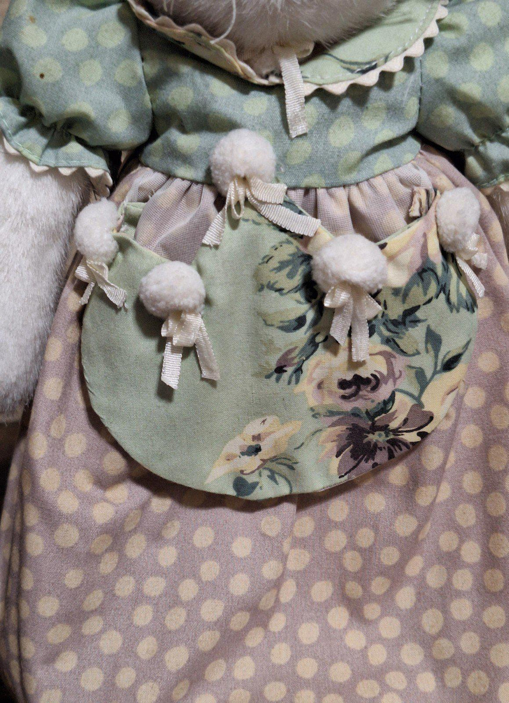 Plush bunny outfit detail: green pocket panel with floral prints and bow ties