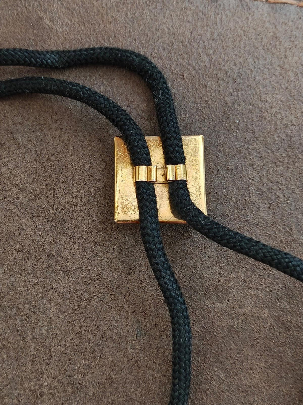 Gold connector and loop on black bolo tie cords
