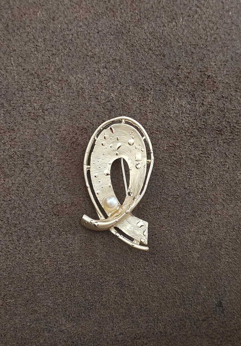 Gold-tone oval abstract brooch pin with faux pearl drop and curved metal frame
