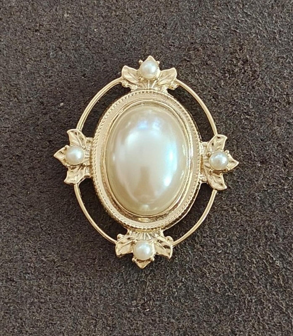 Gold-tone oval faux mabe pearl brooch with starburst edges and pearl drops