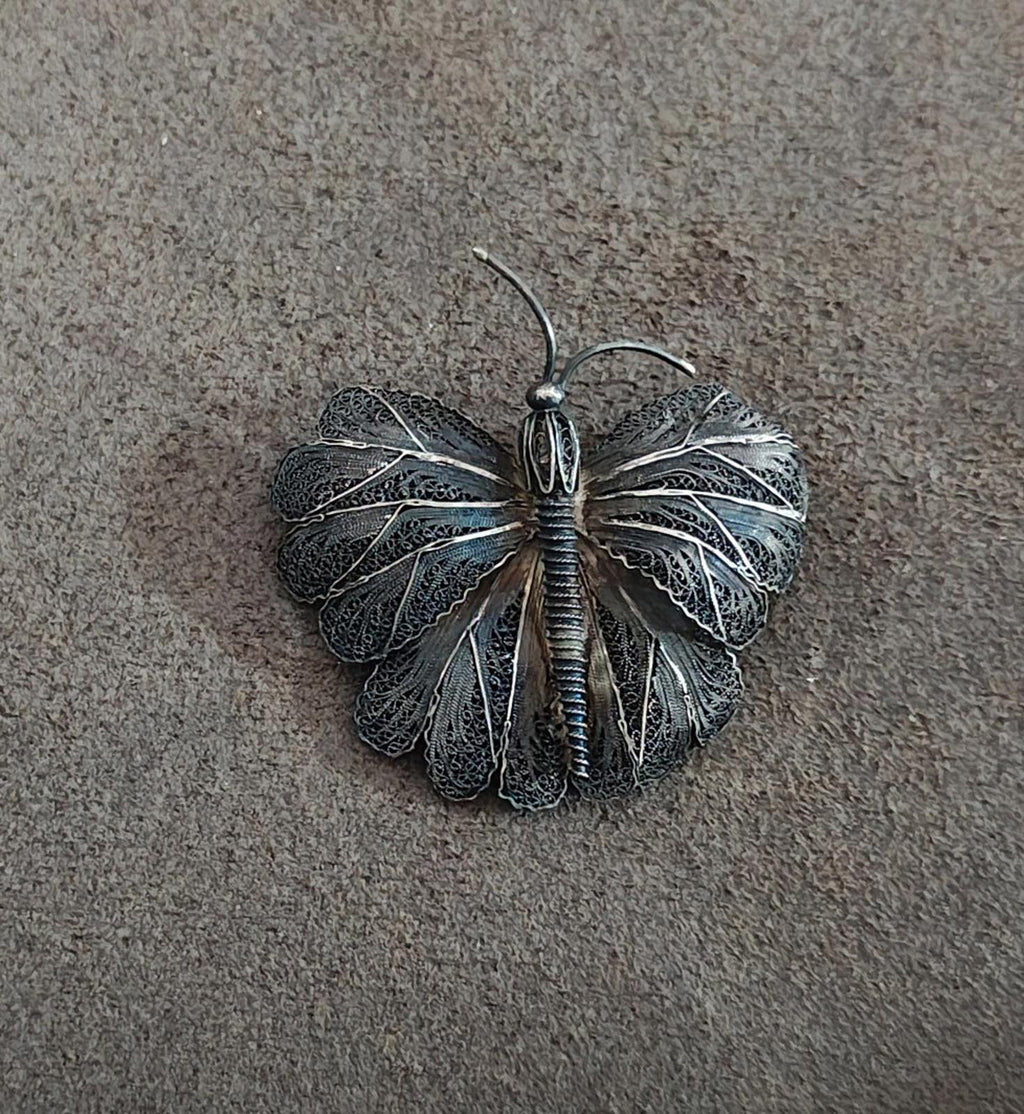 Silver-tone filigree butterfly brooch pin centered view with fan-shaped wings