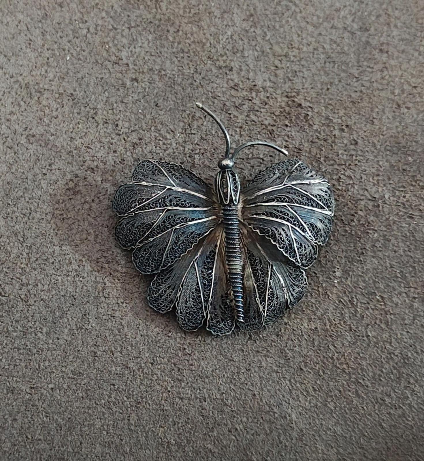Silver-tone filigree butterfly brooch pin centered view with fan-shaped wings