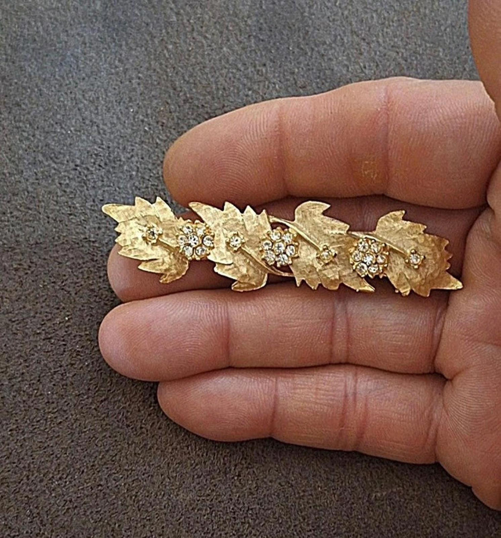 Gold tone leaf and flower rhinestone brooch pin with clustered crystal accents