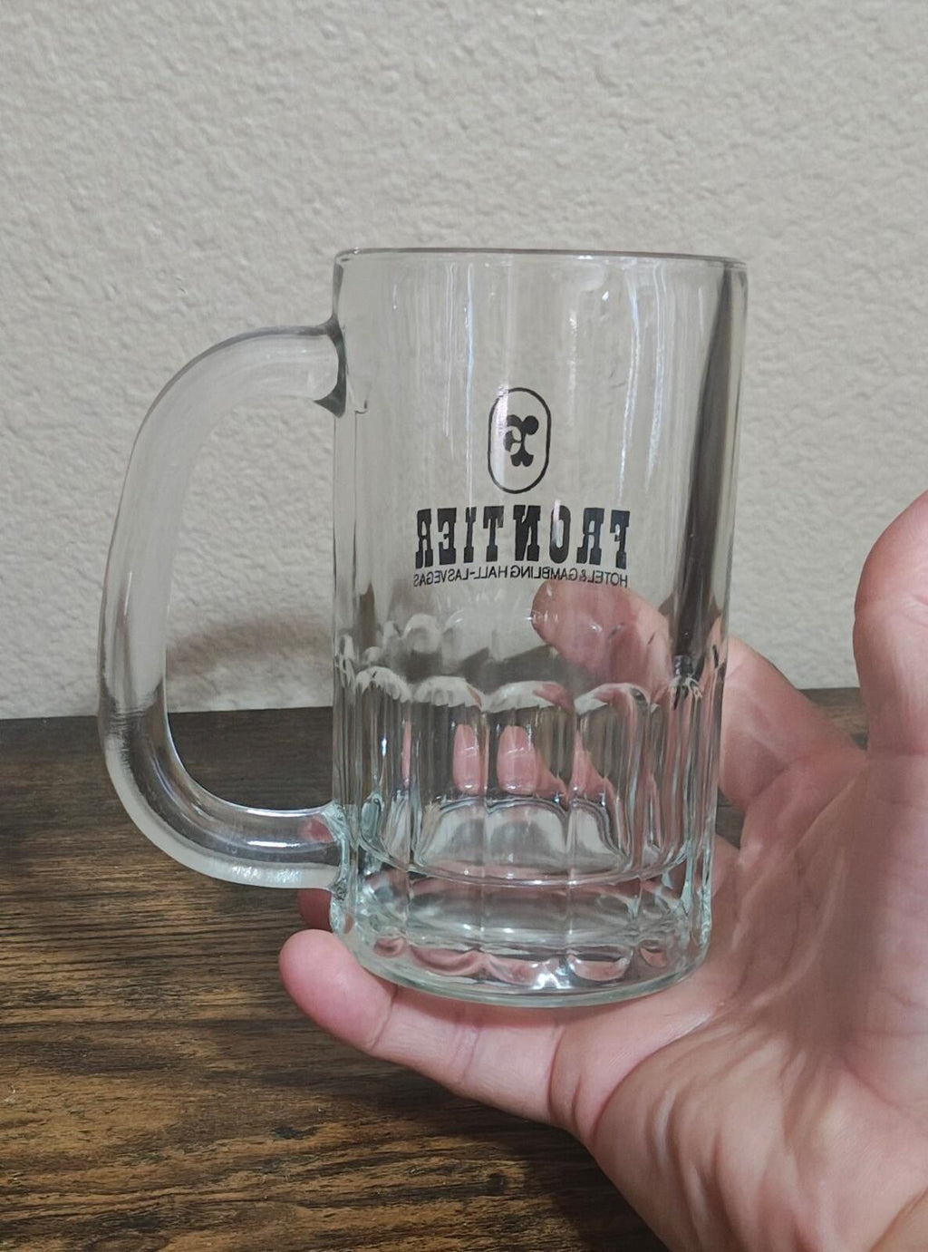 Clear glass beer mug with Frontier logo and arched handle
