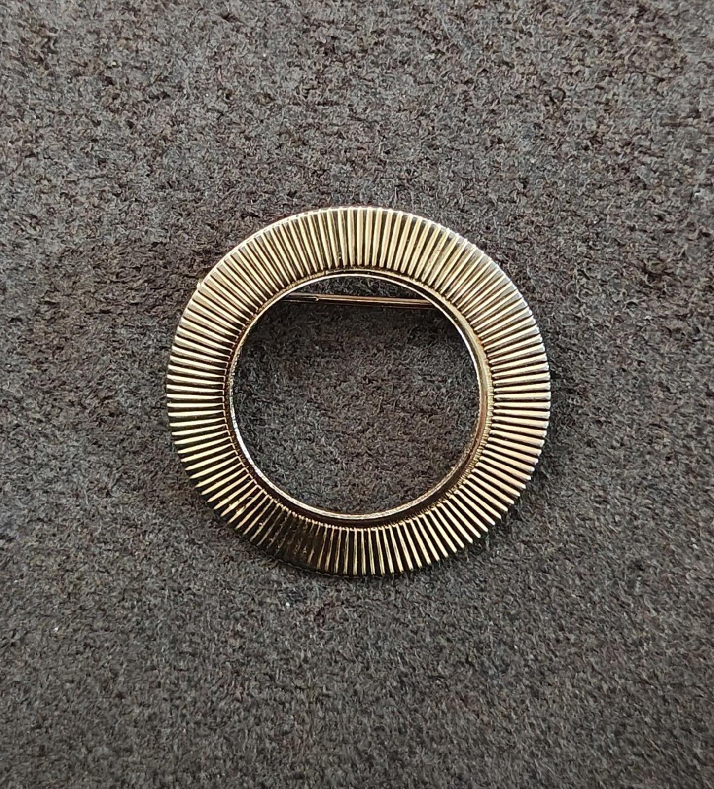 Gold tone ribbed circular brooch pin with open center