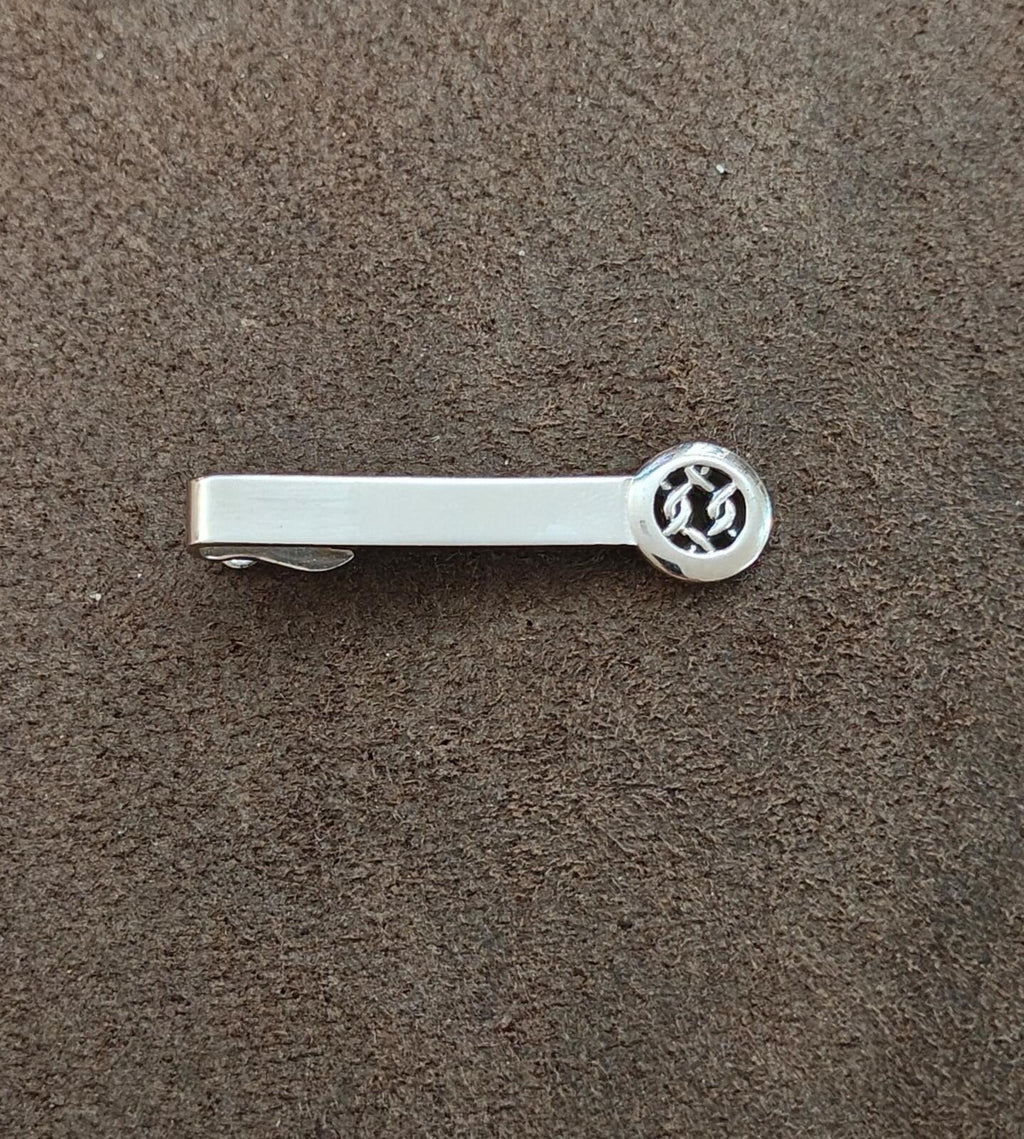 Silver tie bar clip, round Celtic knot medallion end visible