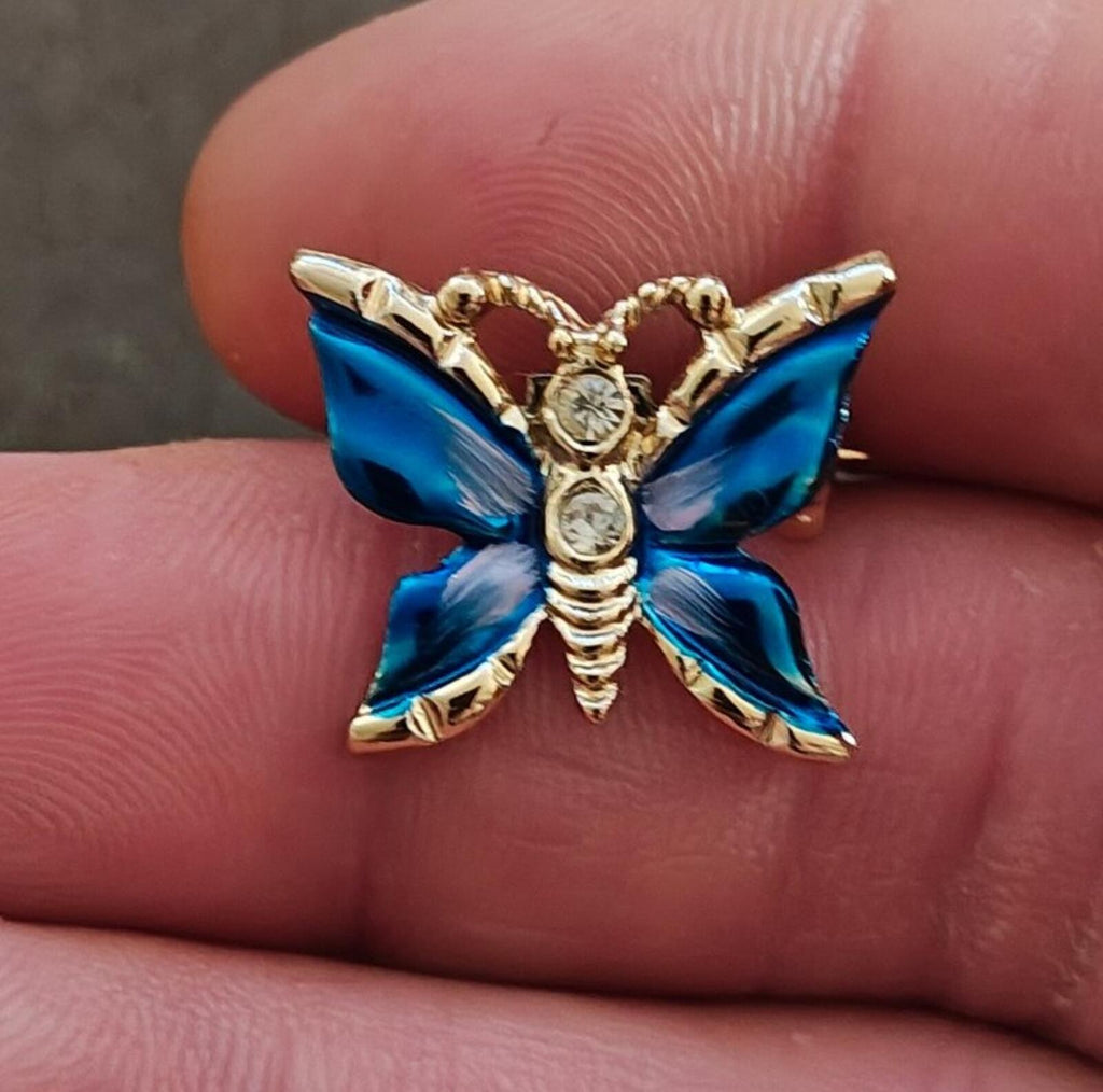 Gold tone butterfly brooch with blue enamel wings and clear rhinestone-studded details
