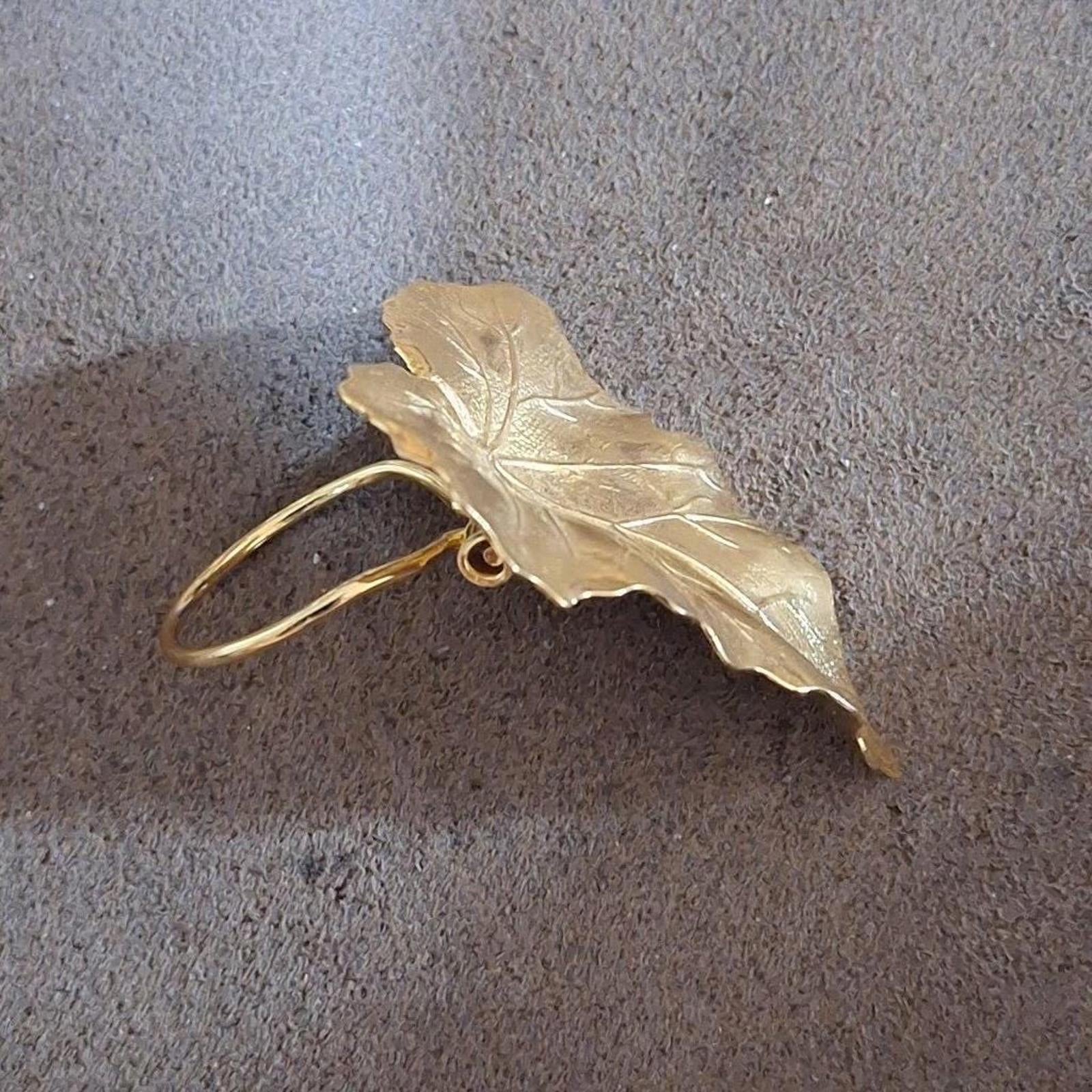 Gold-tone leaf scarf clip side view with two round hoops and hinge detail