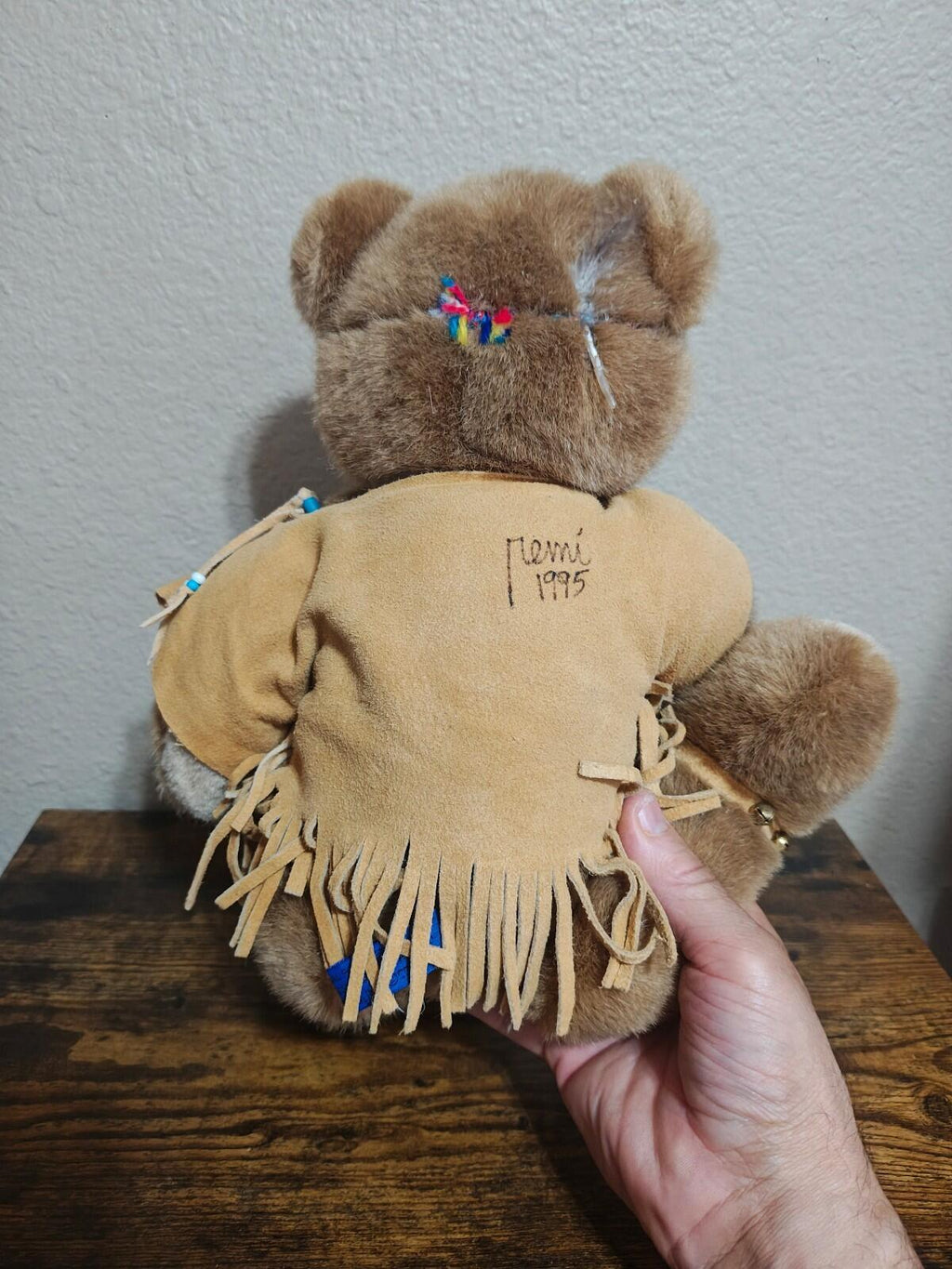 Brown plush bear back embroidery reading 'Paco 1995' with tan fringe outfit