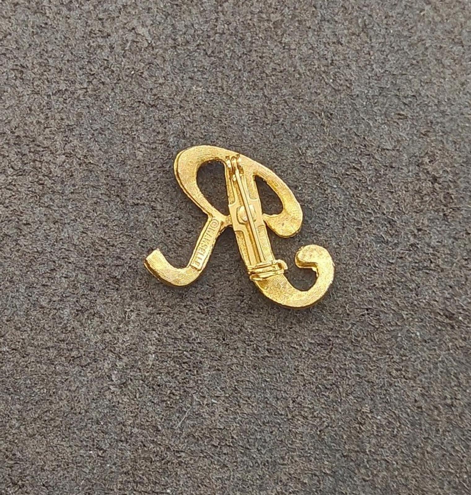 Gold tone letter R monogram brooch pin from side angle