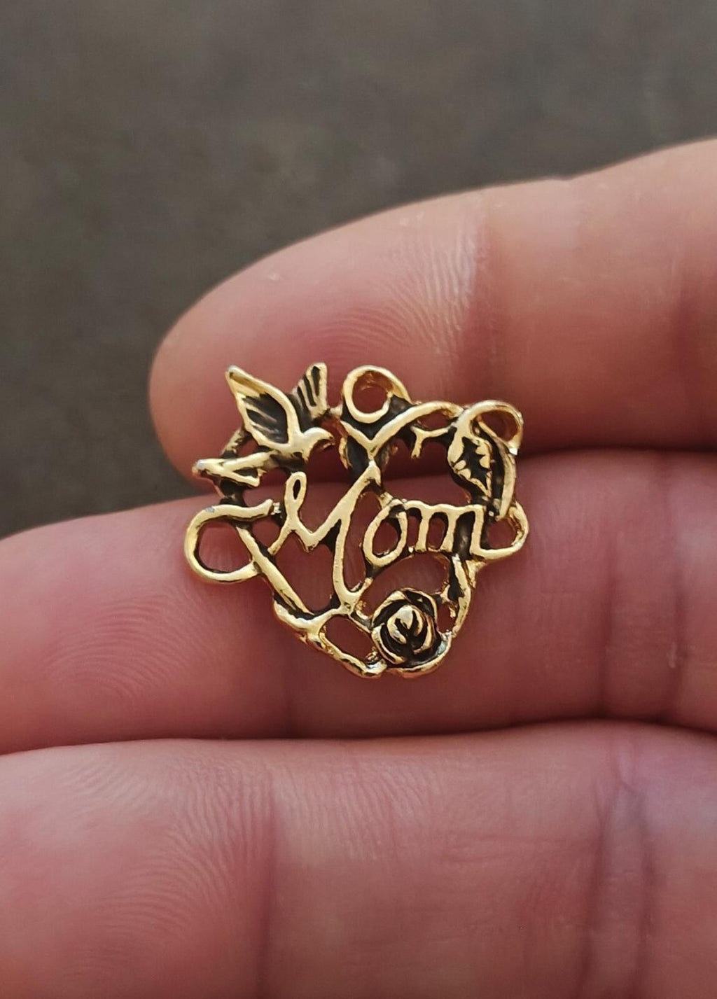 Gold-tone heart pin with floral detailing, rose accent, and “Mom” charm text