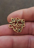 Gold-tone heart pin with floral detailing, rose accent, and “Mom” charm text