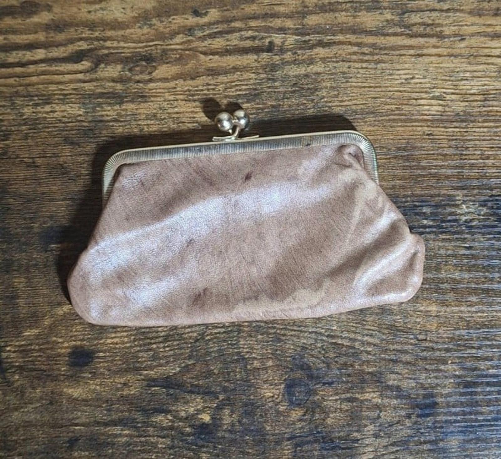 Tan leather coin purse wallet back with metal frame and kiss-lock clasp.