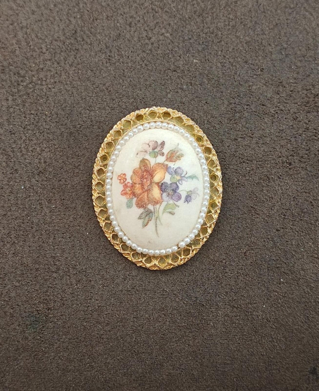 Gold oval ceramic floral brooch with pearl trim and textured ornate edge
