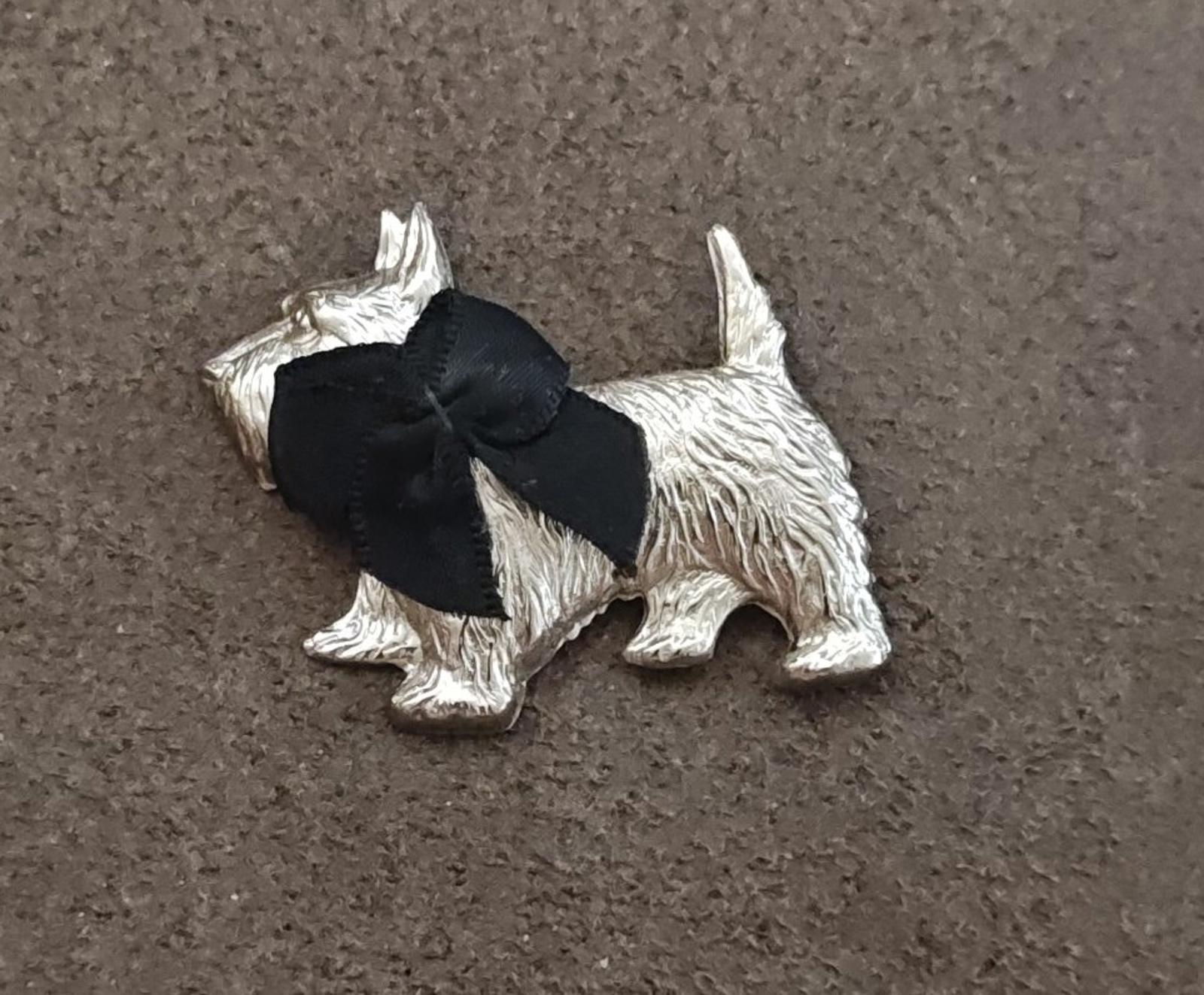 Silver-tone Scottish terrier brooch with black bow, side profile