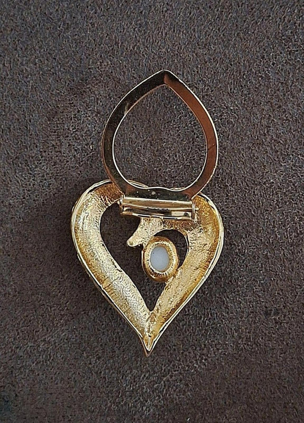 Open back of gold tone heart scarf clip with hanging prong detail