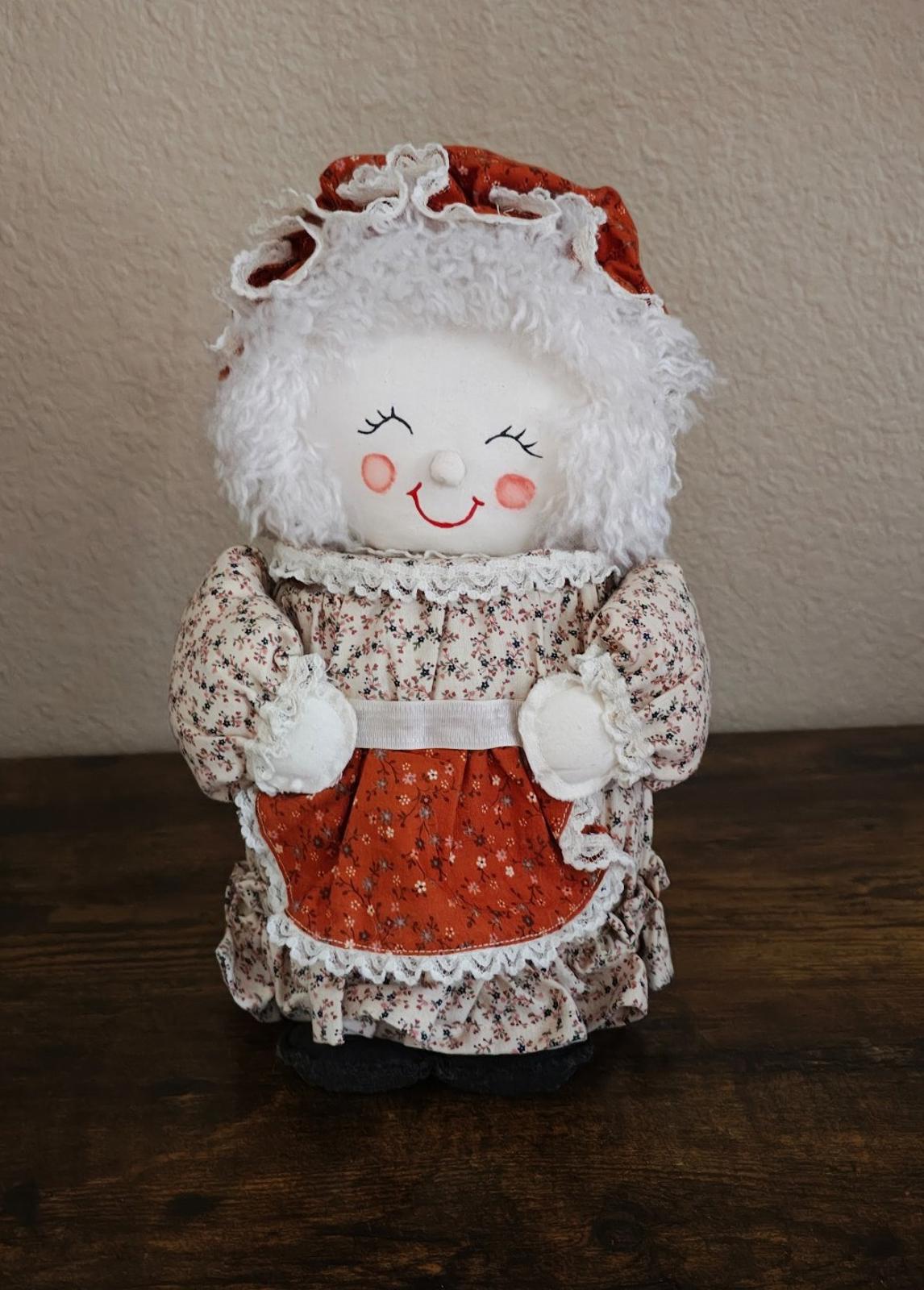 Handmade cloth doll canister standing pose, red skirt and floral apron with lace trim.