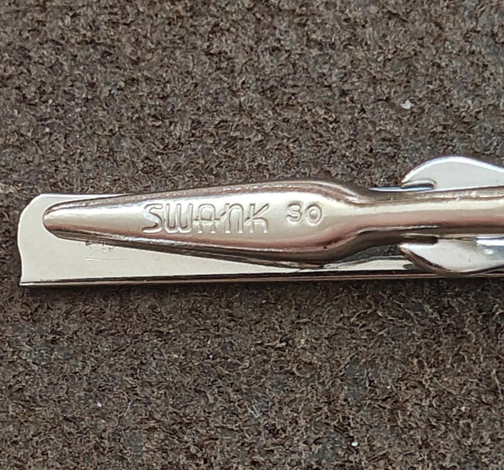 Engraved silver tie bar clip end with SWANK 36 text visible
