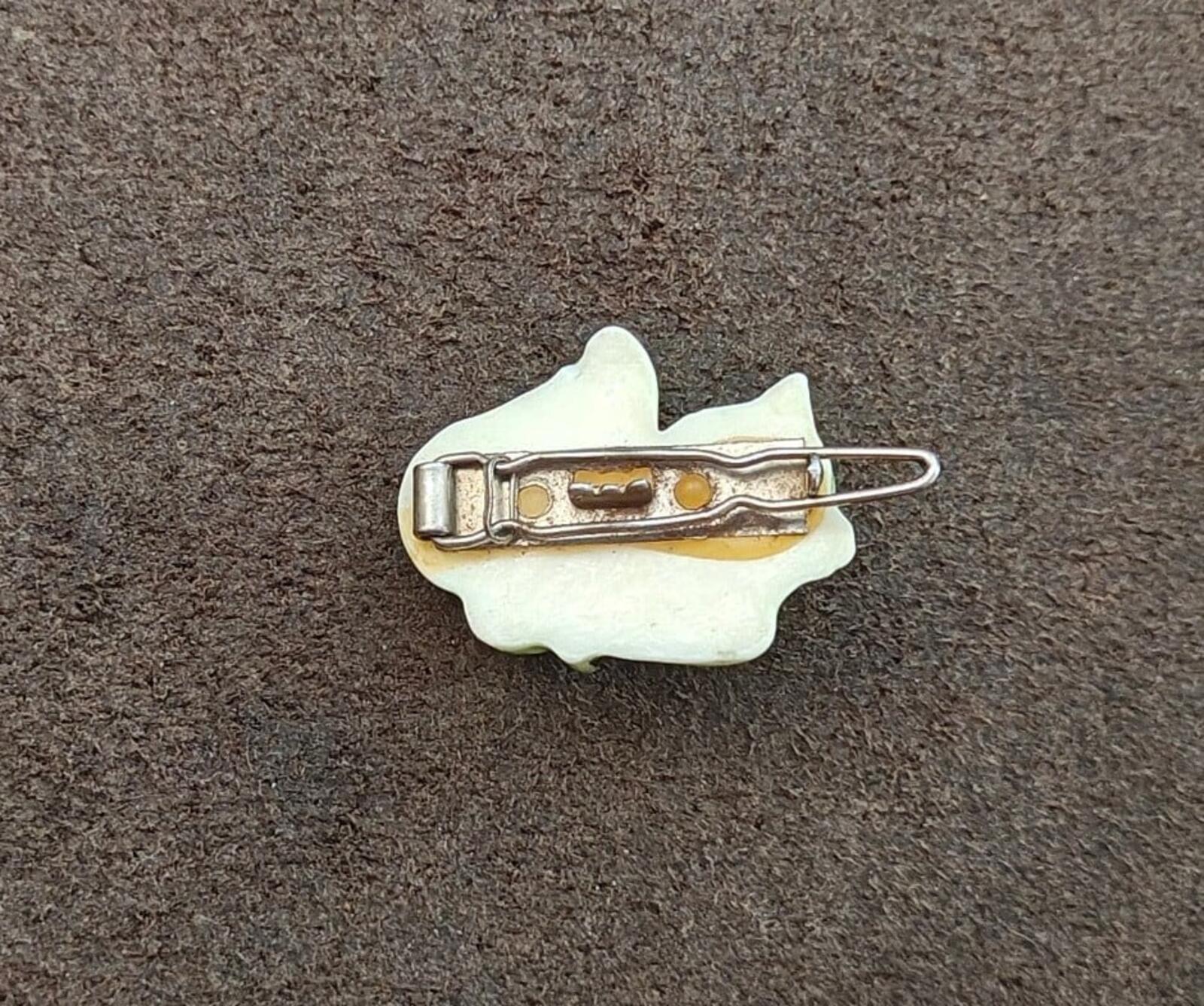 Back of cat hard plastic barrette: white base with gold detail and metal pin