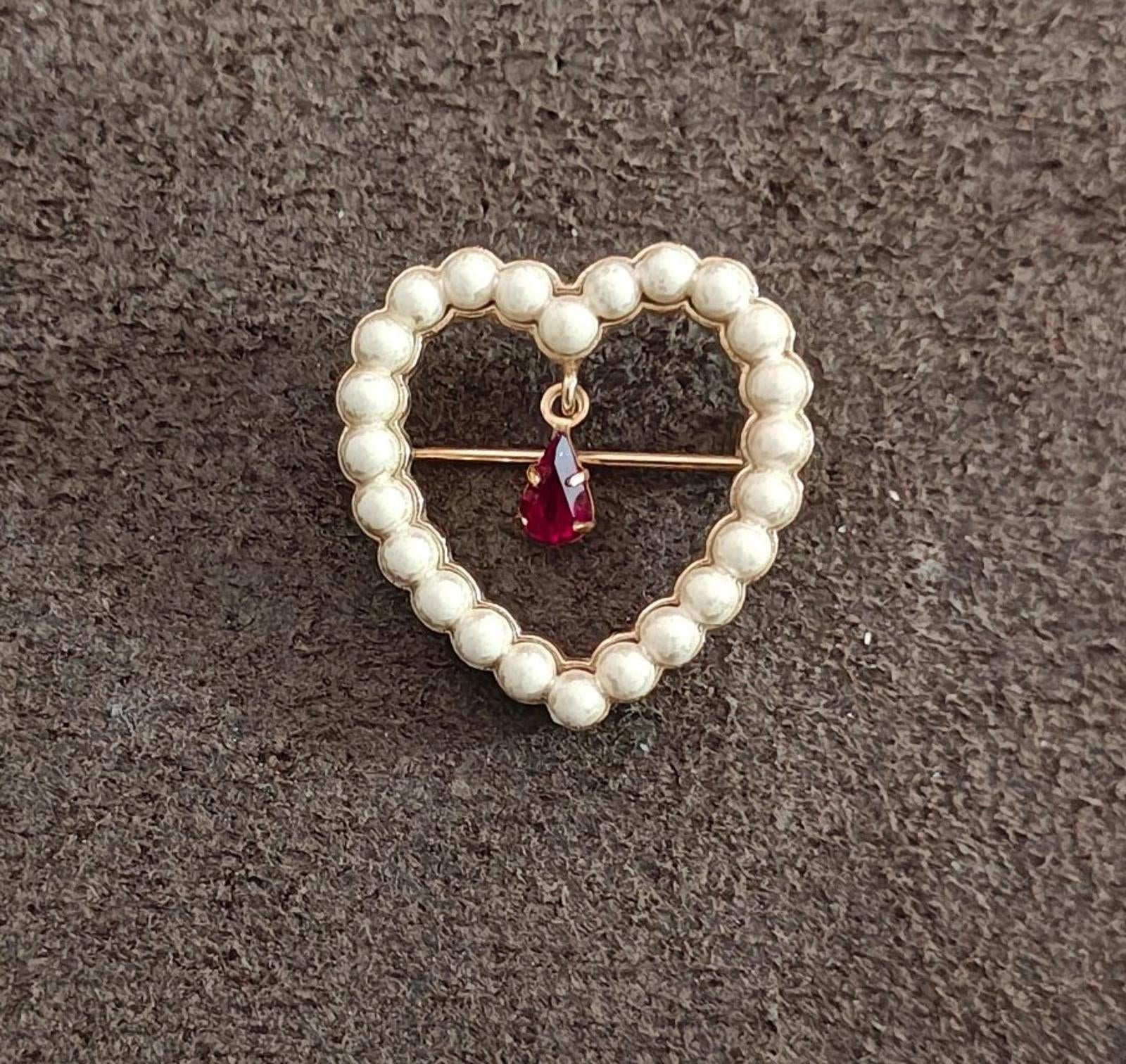 Heart brooch made of white faux pearl beads with a red teardrop rhinestone drop