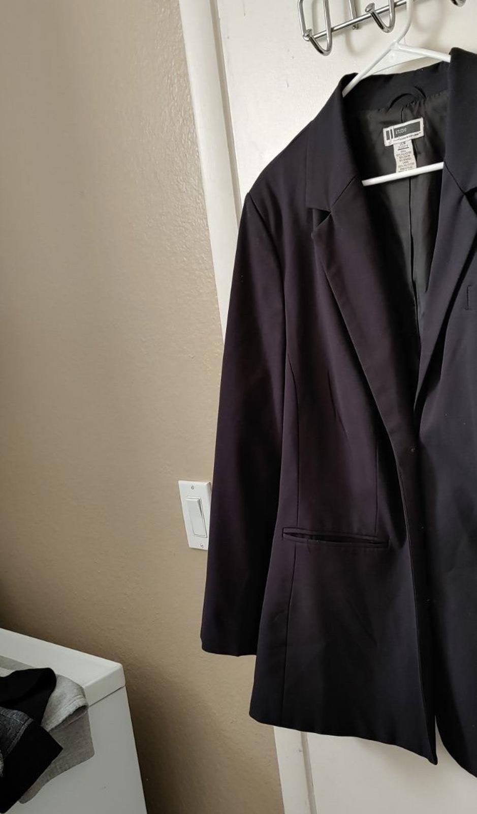 Black longline blazer with flap pockets and notched lapels.