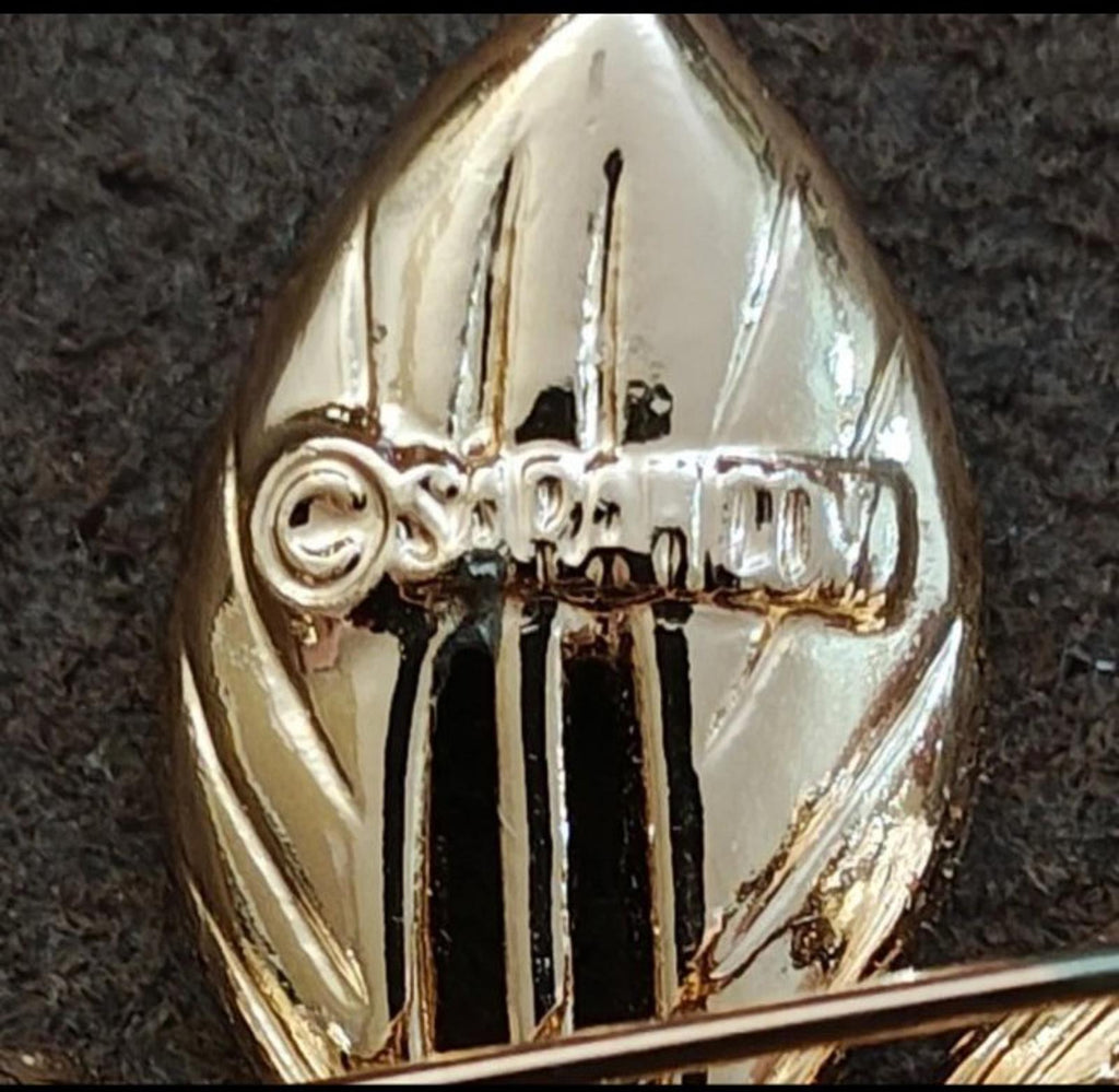 Close-up of gold-tone brooch back with vertical ridges and clasp area detail